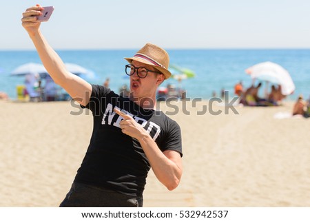 Young handsome Caucasian nerd taking selfie on vacation at beach in Spain