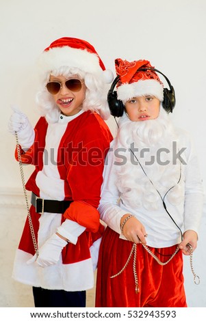 two boys pretending he is a Bad Santa with chains, headphones and sunglasses