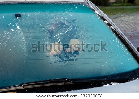 Removing ice from the frozen windshield Royalty-Free Stock Photo #532950076