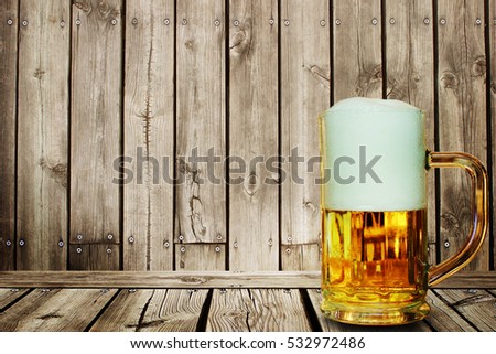 beer in the glass on wooden background