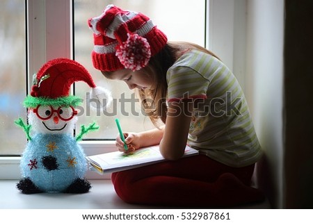 happy Christmas girl with cat writing letter to Santa Claus Royalty-Free Stock Photo #532987861
