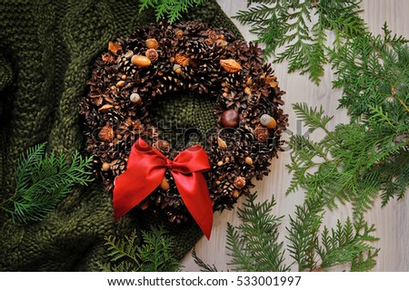 Christmas wreath with knitte sweater wooden background