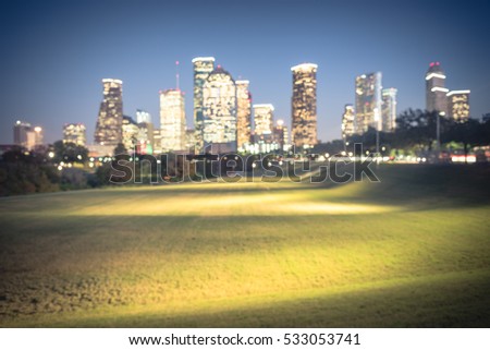 Blurred abstract with bokeh light downtown Houston illuminated at blue hour with green park lawn and modern skylines light. The most populous city in Texas and the fourth-most in America. Vintage tone