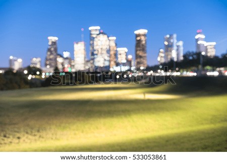 Blurred abstract with bokeh light downtown Houston illuminated at blue hour with green park lawn and modern skylines light. It is the most populous city in Texas and the fourth-most in United States.