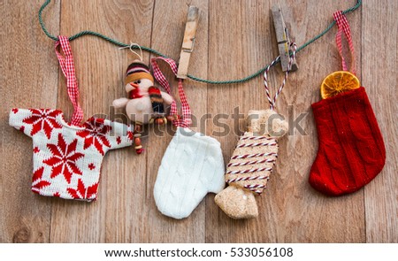 shabby chic christmas background with red and white wool little dresses and  decorations hanging on a wooden background