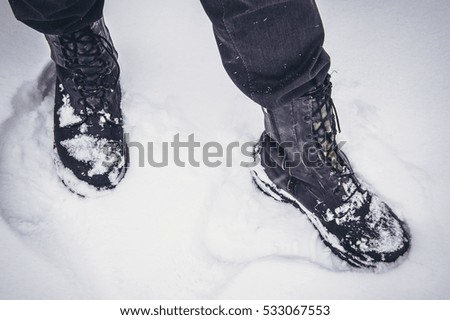 Closeup of hiking, walking boots in the snow.