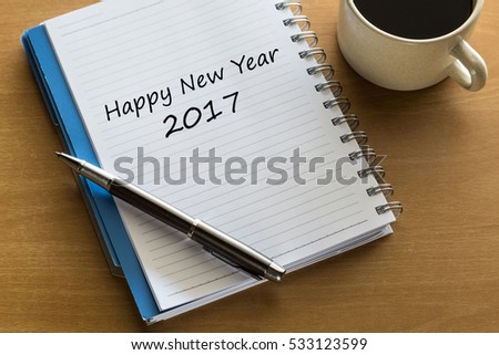 Happy New Year 2017 - handwriting on notebook with cup of tea and pen.