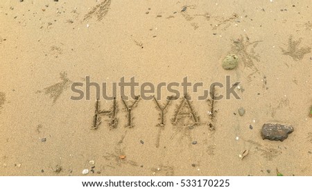 Handwriting words "HY YA!" on sand of beach