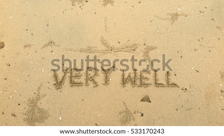Handwriting words "VERY WELL" on sand of beach