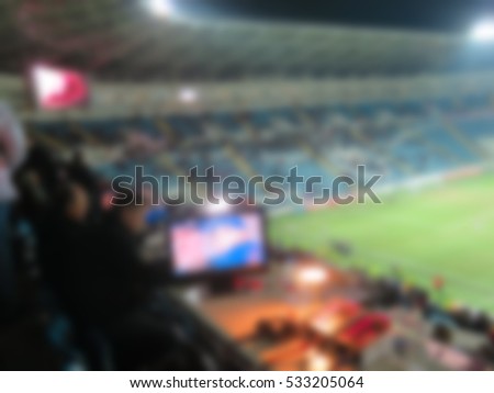   Blurred Empty night grand soccer arena in the lights. Grandstand commentator of the match. Abstract sports background with bokeh.                             