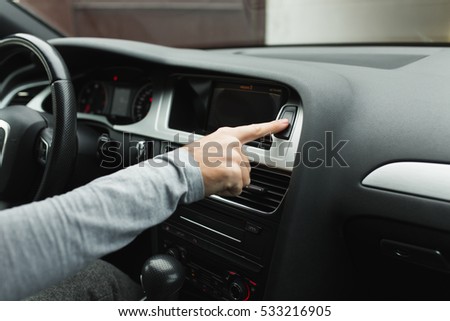 man pushes a button in the car