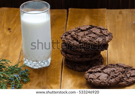 Photo of freshly baked chocolate chips cookies on wooden board