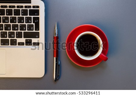 Desk with laptop, eye glasses, pen and a cup of coffee. Top view with copy space.