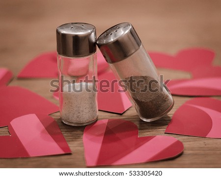  Valentine day creative idea concept, love between salt and pepper in the kitchen. Heart on the background, celebration dinner