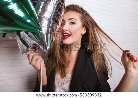 Close up fashionable portrait of cute girl smiling and embracing on white background .Perfect wavy hairstyle. Bright make up. White wall. Party mood,enjoy party,birthday party girl,wear elegant suit 