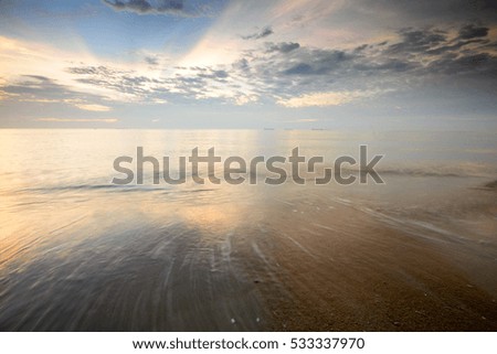 Beautiful dusk sky scenery at seascape with motion blur of waves at foreground. Motion blur on foreground due to slow shutter speed shot. Composition of nature.