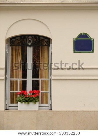 Window with empty road sign in Paris, copy space, suitable for adding custom text, balcony with red geraniums 