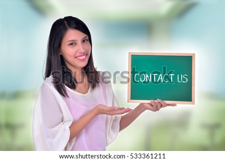 Young Women holding chalkboard with text Contact Us