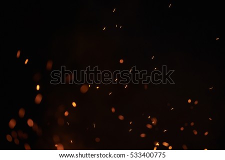 sparks from bonfire over dark night environment, shallow focus Royalty-Free Stock Photo #533400775