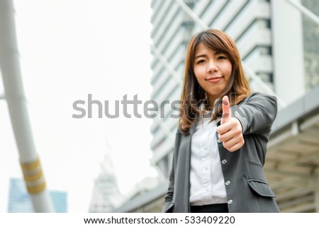 Good hand sign of Smiling businesswoman on cityscape background