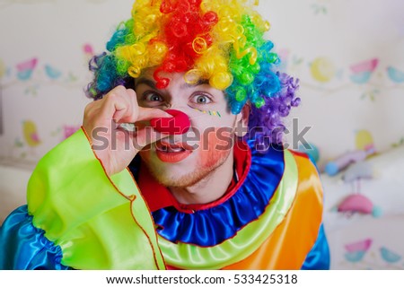 Clown pushes himself on the nose.
