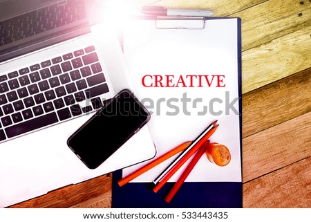 CREATIVE word, text at notepad in wooden table background , retro concepts in wooden with notebook and smartphone.  
