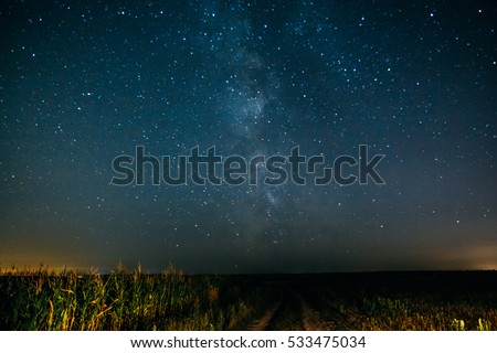 Night sky with the Milky Way and stars over the field