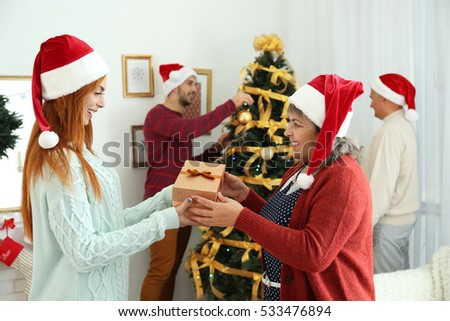 Elderly woman giving Christmas present to her daughter