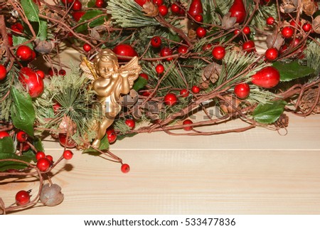 Christmas angel on the background of fir branches with berries