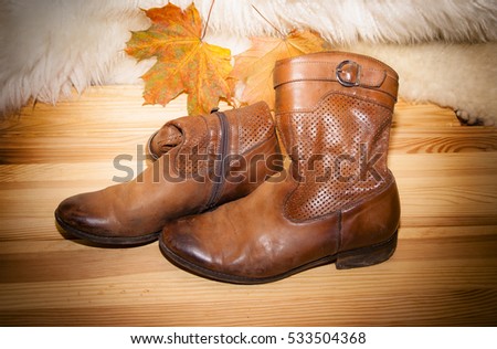 old shoes and leaves on wooden board