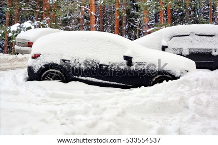 Beautiful winter landscape. Cars covered with snow after huge snowfall. Roads and vehicles hidden under snow.  
