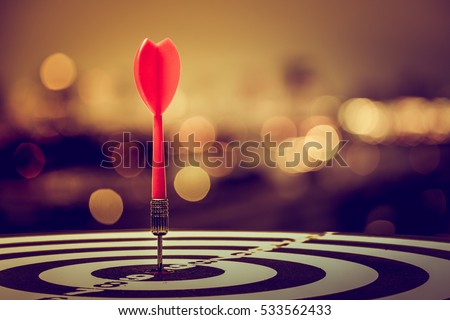 target dart with arrow over blurred bokeh background ,metaphor to target marketing or target arrow concept. Royalty-Free Stock Photo #533562433