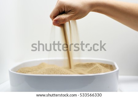 Woman hand with falling sand Royalty-Free Stock Photo #533566330