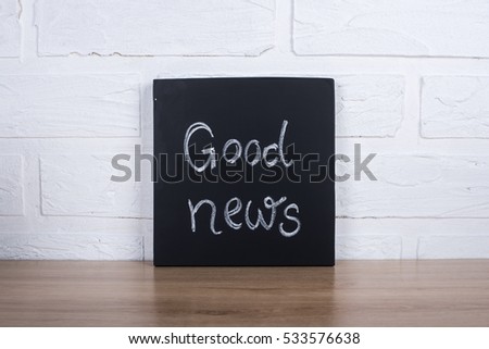 "Good News!" handwritten with white chalk on a blackboard