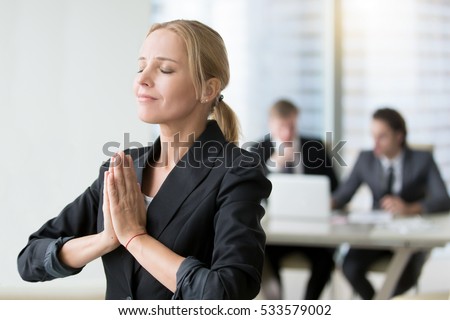 Young businesswoman meditating, habits of successful woman, taking care of herself in personal and business life, staying present and cherishing all the good life. Relaxation techniques at workplace Royalty-Free Stock Photo #533579002