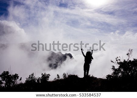 Young Hiker Celebrating Success with open arms up in the air during the Sunrise - Horizontal