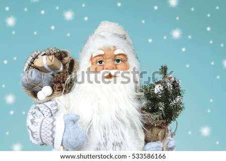 Santa Claus holding up a gift. Christmas decoration.
