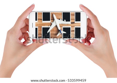 Woman hand using smart phone searching preparation traveling with airplane and photo frame on vintage wooden. Travel concepts, Isolated on white background.