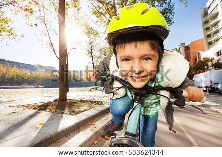 Smiling boy in safety helmet riding his bike Royalty-Free Stock Photo #533624344