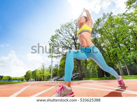 Sporty woman doing stretching exercise at stadium