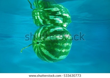 watermelon splashing in water on blue background