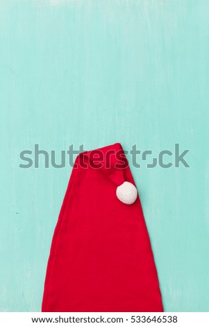Top view on Santa's hat on retro wooden turquoise background. Christmas, winter and holidays season concept