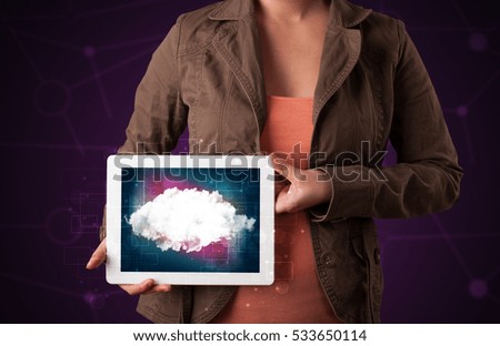 Casual young woman holding tablet with cloud concept and purple background 
