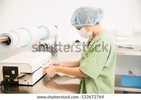 Profile view of a woman in scrubs packing sterile medical instruments in a hospital