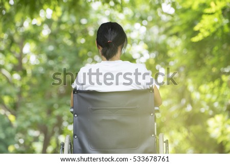 woman using a wheelchair in a park Royalty-Free Stock Photo #533678761