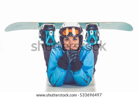 Portrait of beautiful girl in winter sport clothes and goggles posing with a snowboard, isolated on white