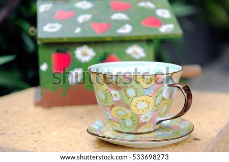 Glass of tea or coffee with small saucer in the garden
