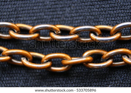 Macro of miniature silver chain on a textile material 