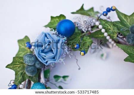 Christmas decorative wreath with ivy leaves, fir-tree balls and artificial flowers