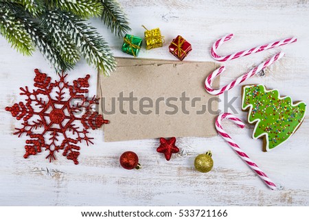 Christmas decoration and old paper on blue wooden table. Snowflakes, gifts, candies and fir branches on a wooden background.